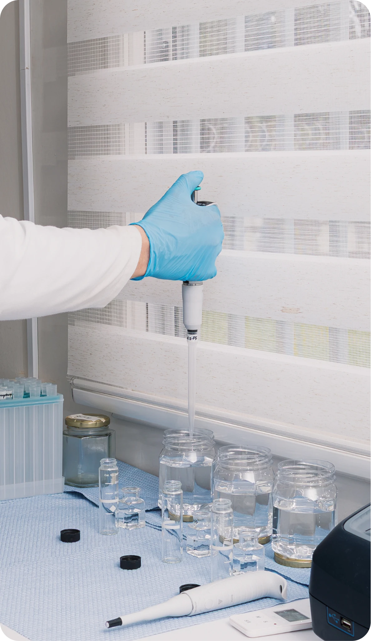 Laboratory analyst pipetting samples into glass vials